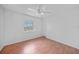 This bedroom has wood floors, a ceiling fan with a light and a sunny window at 657 Hartford Nw Dr, Port Charlotte, FL 33952