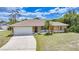 Attractive single-story home with a well-manicured lawn, landscaping and attached two-car garage at 657 Hartford Nw Dr, Port Charlotte, FL 33952