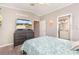 Bright bedroom with gray walls, wood floors, a patterned blue bedspread, and ensuite bathroom at 714 Fairmount Dr, North Port, FL 34287