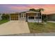 Charming single-story home with a covered porch, enclosed carport, and well-maintained landscaping at 714 Fairmount Dr, North Port, FL 34287