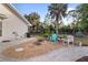 Picturesque backyard with a cozy fire pit, charming seating, and lush tropical landscaping at 719 Ellicott Nw Cir, Port Charlotte, FL 33952