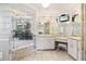 Bathroom features a soaking tub under a window and double vanity with television at 719 Ellicott Nw Cir, Port Charlotte, FL 33952