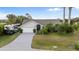Well-manicured single-story home with RV parking and tropical landscaping at 719 Ellicott Nw Cir, Port Charlotte, FL 33952