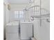 Functional laundry room with modern washer and dryer, and shelving at 719 Ellicott Nw Cir, Port Charlotte, FL 33952