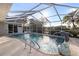 Screened in pool featuring a dolphin fountain and tropical landscaping for a resort-like feel at 719 Ellicott Nw Cir, Port Charlotte, FL 33952