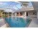 The screened-in pool area is ideal for relaxing and has a built-in bar, ladder, shower and lush greenery at 719 Ellicott Nw Cir, Port Charlotte, FL 33952