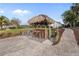 Outdoor tiki bar and lounge area with a thatched roof, perfect for entertaining guests at 719 Ellicott Nw Cir, Port Charlotte, FL 33952