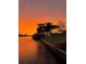 Scenic waterfront view at sunset, with palm trees lining the shoreline, displaying tranquil beauty at 719 Ellicott Nw Cir, Port Charlotte, FL 33952
