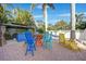 Inviting outdoor seating with bright chairs, tropical foliage and custom hardscape at 740 W Virginia Ave, Punta Gorda, FL 33950
