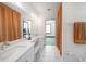 Bathroom with dual vanity, white cabinets, and views into the bedroom at 740 W Virginia Ave, Punta Gorda, FL 33950