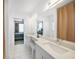 Bathroom with dual vanity, white cabinets, and views into the bedroom at 740 W Virginia Ave, Punta Gorda, FL 33950