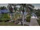 Charming home with lush landscaping, a spacious wrap-around porch, and a striking blue metal roof, creating a tropical paradise at 740 W Virginia Ave, Punta Gorda, FL 33950