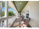 Long front porch features a seating area, offering a comfortable space to enjoy the surrounding views and natural light at 740 W Virginia Ave, Punta Gorda, FL 33950