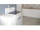 Bright kitchen with white appliances, tiled flooring, and ample cabinet space at 8544 Herbison Ave, North Port, FL 34287