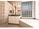 Bright bathroom featuring tub with marble surround and glass block window letting in natural light at 10227 Windsong Rd, Punta Gorda, FL 33955