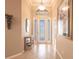 Bright foyer with tile flooring, decorative lighting, display cabinet, and an arched window above the front door at 10227 Windsong Rd, Punta Gorda, FL 33955