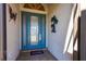 Inviting blue front door with decorative glass panels and elegant hardware, adorned with decorative wall art at 10227 Windsong Rd, Punta Gorda, FL 33955
