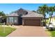 Inviting home featuring a tile roof, paver driveway, and meticulously maintained landscaping at 10227 Windsong Rd, Punta Gorda, FL 33955