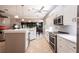 Open kitchen with white cabinets, stainless steel appliances, breakfast bar and a view of the adjacent living areas at 10227 Windsong Rd, Punta Gorda, FL 33955