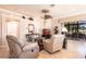 Cozy living room with comfortable seating, ceiling fan, neutral color palette, and access to a screened lanai at 10227 Windsong Rd, Punta Gorda, FL 33955