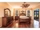 Elegant primary bedroom featuring hardwood floors, a ceiling fan, and outdoor access at 10227 Windsong Rd, Punta Gorda, FL 33955