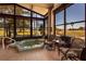 Bright sunroom featuring a hot tub, tile floors, large windows, and comfortable seating areas at 10227 Windsong Rd, Punta Gorda, FL 33955