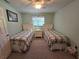 Bright bedroom featuring twin beds, a ceiling fan, and a window providing natural light at 1173 Belkton Ave, Port Charlotte, FL 33948