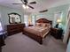 Spacious bedroom with a large bed, decorative mirror, ceiling fan and dual night stands at 1173 Belkton Ave, Port Charlotte, FL 33948
