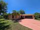 Single-story home with a brown roof, two car garage, and a long pink patterned driveway at 1173 Belkton Ave, Port Charlotte, FL 33948