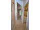 Hallway with beige walls, tile floors, and doors leading to different rooms of the house at 1173 Belkton Ave, Port Charlotte, FL 33948