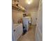 Functional laundry room with washer, dryer, utility sink, storage shelves and tile flooring at 1173 Belkton Ave, Port Charlotte, FL 33948