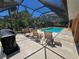 Screened pool area with lounge chairs and table, surrounded by lush landscaping at 1173 Belkton Ave, Port Charlotte, FL 33948