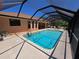 Screened pool with a sunny patio and lounge chairs offers a relaxing outdoor space at 1173 Belkton Ave, Port Charlotte, FL 33948