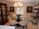 Formal dining room with a glass table, chandelier, and curated decorative display at 1233 Dewhurst St, Port Charlotte, FL 33952