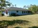 Exterior view of a blue home with a screened patio and well maintained backyard at 1233 Dewhurst St, Port Charlotte, FL 33952