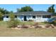 Charming single-story home with a light blue exterior, a well-kept lawn and front garden with an arched entryway at 1233 Dewhurst St, Port Charlotte, FL 33952