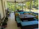 Screened patio with cushioned seating, dining area, and views of the lush backyard at 1233 Dewhurst St, Port Charlotte, FL 33952