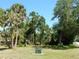 View of a vacant lot with mature trees, clear sky and residential street at 1233 Dewhurst St, Port Charlotte, FL 33952