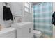 A pristine bathroom featuring a white vanity, a modern faucet, and a shower with a striped curtain at 1249 Indus, Venice, FL 34293
