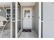 Inviting entryway featuring a tiled floor, a colorful doormat and a white front door with window panes at 1249 Indus, Venice, FL 34293