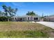 Charming single-story home with neutral paint, a palm tree, and a well-manicured front yard at 1249 Indus, Venice, FL 34293