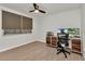 Bedroom features a spacious desk area, laminate floors, and a ceiling fan at 125 Donna Ct, Punta Gorda, FL 33950