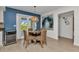 Cozy dining area with rattan chairs, accent wall and an adjacent wine fridge near the sliding glass door at 125 Donna Ct, Punta Gorda, FL 33950