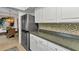 Modern kitchen with stainless steel refrigerator, and mosaic tile backsplash at 125 Donna Ct, Punta Gorda, FL 33950