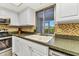 Kitchen sink with a window view to the screened porch features tiled backsplash, granite counters, and white cabinets at 125 Donna Ct, Punta Gorda, FL 33950