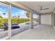 Covered patio with tile flooring, ceiling fan, sliding glass doors, and view of the pool and canal at 125 Donna Ct, Punta Gorda, FL 33950