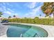 Inviting pool area featuring tropical landscaping, clear blue water, and comfortable lounge chairs at 125 Donna Ct, Punta Gorda, FL 33950