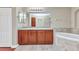 Bathroom featuring double sinks with granite countertop and a soaking tub next to the vanity at 1349 Aqui Esta Dr # 121, Punta Gorda, FL 33950