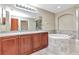 Granite countertop in a spacious bathroom with large mirror and soaking tub at 1349 Aqui Esta Dr # 121, Punta Gorda, FL 33950