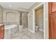Well-lit bathroom featuring glass shower, soaking tub, and tile floor at 1349 Aqui Esta Dr # 121, Punta Gorda, FL 33950